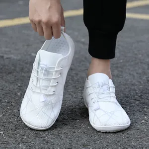 White barefoot hiking shoes with wide toe box and breathable mesh on asphalt road