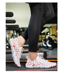 Détail de chaussures aquatiques blanches à motif nid d'abeille rouge sur tapis roulant