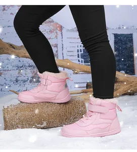 Detail of pink kids snow boots featuring plush faux fur lining and velcro strap closure
