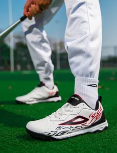 Detailed side view of white soccer cleats with red and black flame patterns on turf