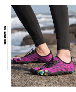 Gros plan de chaussures aquatiques violettes avec cordon élastique sur les rochers