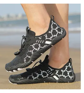 Détail de chaussures aquatiques noires à motif alvéolé avec cordon de serrage à la plage