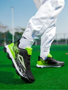 Detailed side view of turf soccer shoes with flame patterns on green grass field