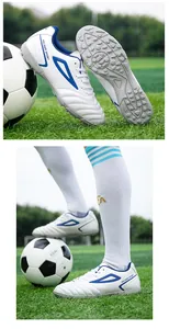 Close-up of white and blue turf soccer shoes with durable rubber studs and stitched toe