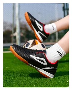 Detalle de bota de fútbol en cuero negro con tacos de goma y forro interior rojo