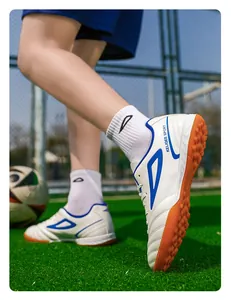 Detalle de la suela de goma y el logo KELIQEE SPORT en el zapato de fútbol blanco y azul