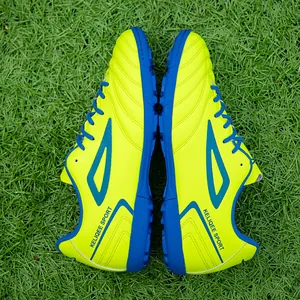 Neon yellow and blue turf soccer shoes for men with rubber studs on artificial grass