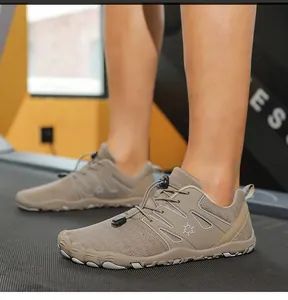 Detail van bruine blotevoetenschoenen met mesh bovenwerk en snelveters op een loopband