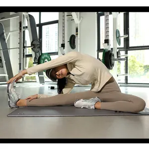 Détail d'un ensemble de sport beige avec veste à capuche et legging lors d'un étirement de yoga
