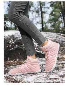 Close-up of pink waterproof snow boots with warm faux fur lining and non-slip white soles