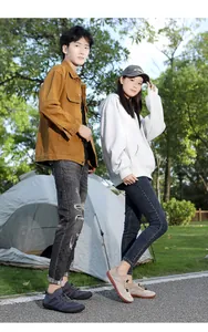 Outdoor street shot of lightweight breathable mesh sneakers with elastic cord laces on grass