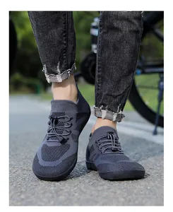 Outdoor shot of dark grey barefoot shoes with breathable knit fabric and quick-lace toggles