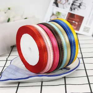 0.6cm satin ribbons with gold edges in various colors on a ceramic plate