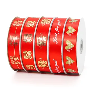 Rode satijnen linten met gouden Xi-teken en Just for you prints op witte rollen
