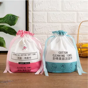 Disposable cotton face towels in pink and blue drawstring bags for dry and wet skin care