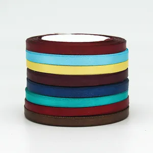 Stack of multi-colored 6mm satin ribbons for gift wrapping and DIY crafts on white background