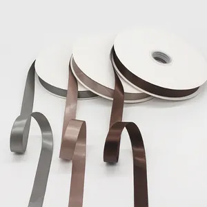 Satin ribbon rolls in coffee and silver tones for gift wrapping and DIY crafts
