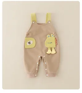 Detail der Baby-Latzhose mit süßem 3D-Dinosaurier-Aufnäher und Druckknöpfen auf Baumwolle