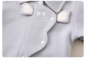 Detail of baby cotton top featuring 3D elephant ears and fine embroidery with white buttons