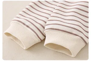 Detailaufnahme eines gestreiften Baby-Oberteils mit weichen Rippbündchen und Strick