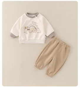Dettaglio del set neonato in cotone con grafiche di dinosauro e pantaloni con elastico