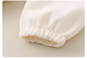 Detailed close-up of elastic ribbed cuffs on a beige cotton sweatshirt for children