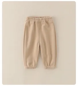 Dettaglio dei pantaloni sportivi in cotone per neonato con vita elastica e polsini kaki