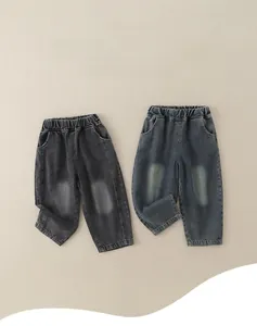 Detail view of boys' elastic waist denim pants with faded wash and rolled cuffs style