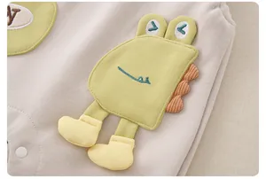 Detail eines Babyoutfits mit grüner Dino-Stickerei, 3D-Akzenten und Baumwollstoff