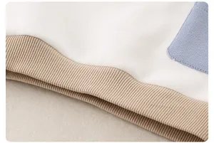 Detailaufnahme von weißem Waffelstrick aus Baumwolle mit weichen Rippbündchen für Kinder