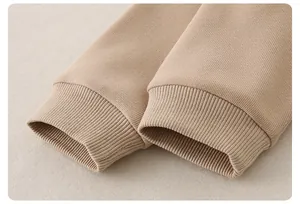 Nahaufnahme der gerippten Bündchen an einem khakifarbenen Strickpullover für Kleinkinder