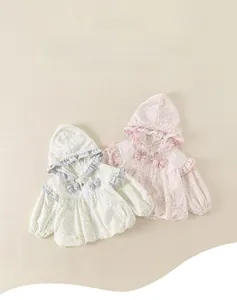 Detail of baby girls hooded jackets featuring floral patterns and lace ruffles