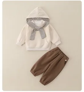 Detail view of cotton two-piece kids tracksuit with striped hooded sweatshirt and brown pants