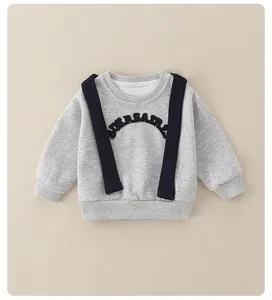 Detail of grey baby sweatshirt featuring decorative black straps and ribbed cuffs