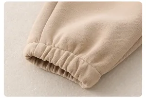 Dettaglio dei polsini elastici a costine su una tuta in cotone beige per bambini