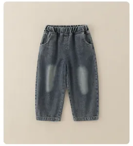 Detailed view of elastic waistband and wash texture on boys dark grey denim jeans