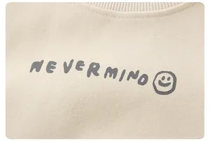 Close-up of beige cotton sweatshirt with ribbed crewneck and Nevermind smiley print