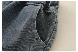 Detailed macro view of boys' denim jeans showing elastic waist and washed fabric texture