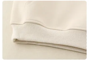 Detailed view of ribbed hem and fine stitching on a beige cotton hoodie for kids