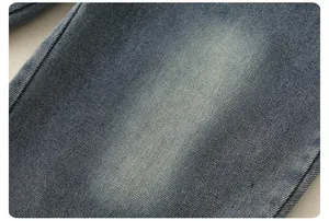 Close-up of deep blue denim fabric texture with stone wash and faded details