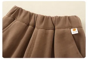 Detail of baby brown knit pants featuring an elastic waist and size 90 fabric label