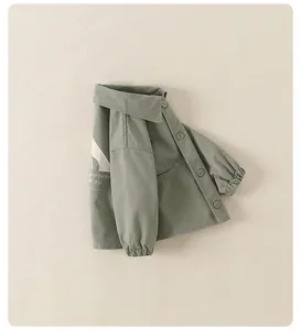 Détail d'une veste enfant gris-vert montrant les poignets et l'imprimé au dos