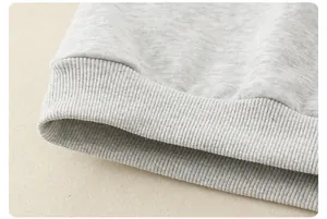 Detailed close-up of light gray ribbed cuff on a children's knit sweatshirt