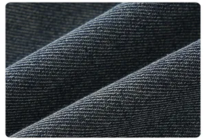 Macro detail of dark blue twill denim fabric showing high-quality texture and stitching