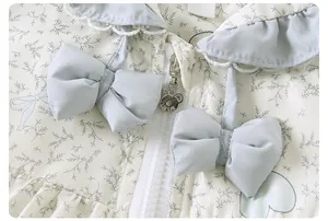 Detail of floral baby jacket featuring ruffled lace collar and cute bear-shaped zipper pull