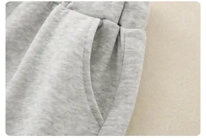 Close-up of children's grey cotton tracksuit pants showing pocket and elastic waistband