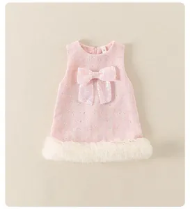 Detalle de vestido de tweed rosa para niña con lazo de lentejuelas y ribete de plumas blancas