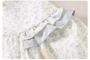 Detailed close-up of floral print fabric with blue ruffled edges for girl's spring jacket