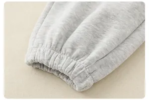 Close-up of light gray knitted fabric texture and elastic ribbed cuffs for kids outfits