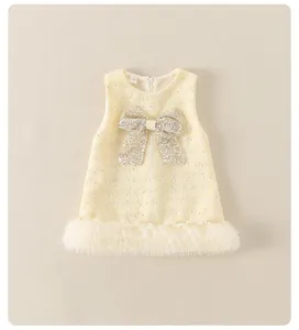 Detalle de vestido de tweed para niña con lazo de lentejuelas y ribete de malla blanca
